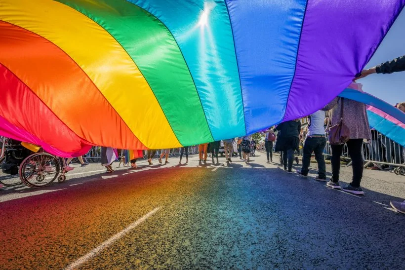 Gay pride parade people marching with a large flag, reykjavik, iceland
