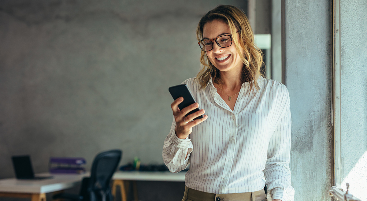Smiling businesswoman using phone in office